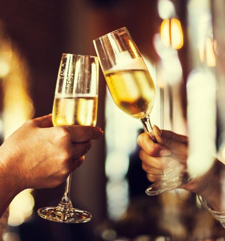 Two glasses clinking together representing Alhambra Theatre partnership perks